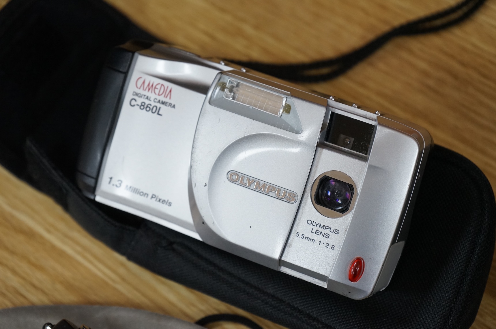 A cased Olympus 35SP camera, together with two more recent digital cameras